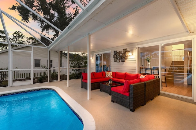 pool at dusk with a patio, a lanai, and an outdoor hangout area