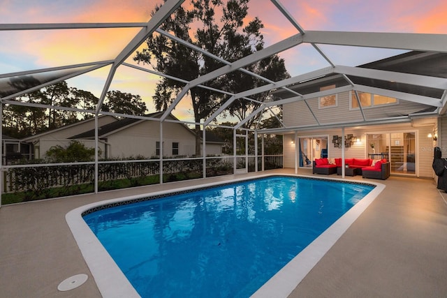 pool at dusk featuring a patio area, a lanai, and an outdoor living space