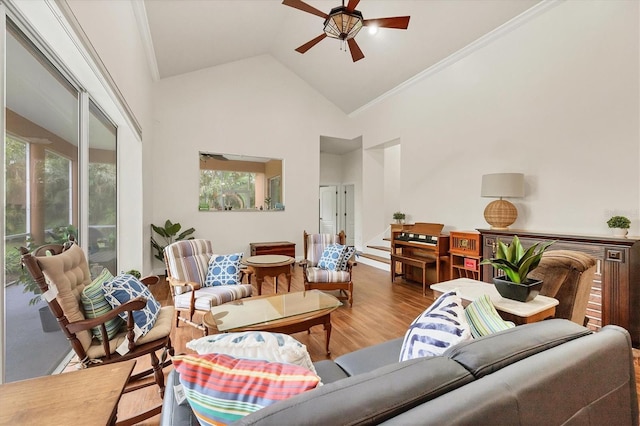 living room with hardwood / wood-style floors, crown molding, high vaulted ceiling, and ceiling fan