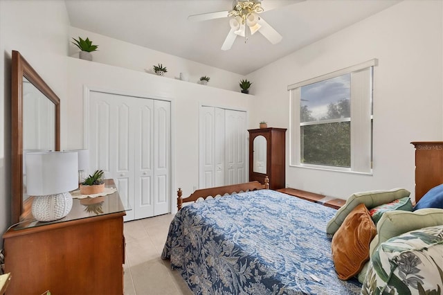 bedroom with two closets, light tile patterned floors, and ceiling fan