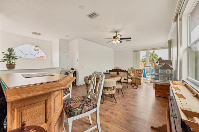 dining room featuring crown molding, hardwood / wood-style flooring, and ceiling fan