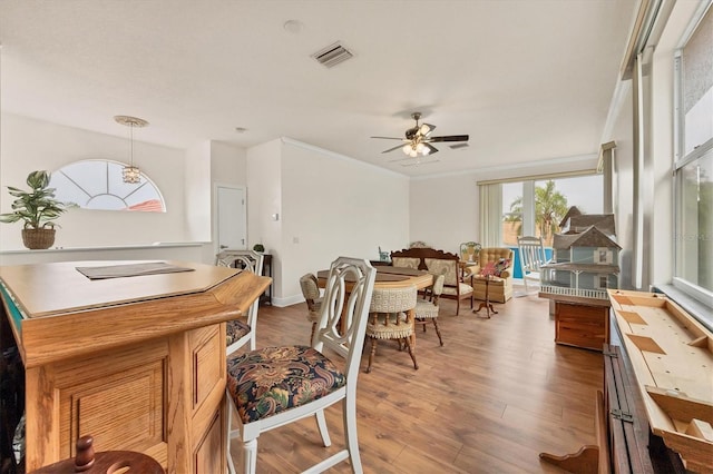7341 Featherstone Blvd, Sarasota, FL 34238 - dining space featuring light wood-style floors, ceiling fan, and crown molding