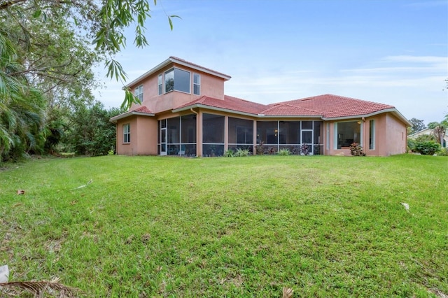 back of property featuring a lawn and a sunroom