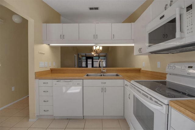 kitchen featuring white cabinetry, sink, light tile patterned flooring, and white appliances