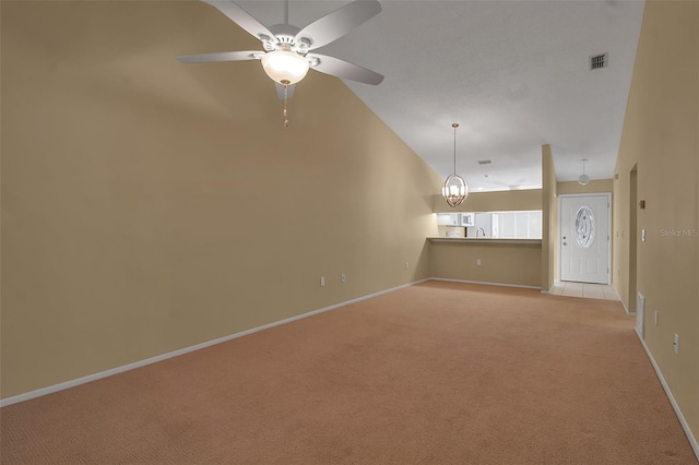 unfurnished living room with ceiling fan, light colored carpet, and lofted ceiling