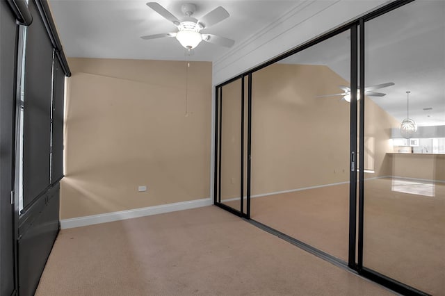 unfurnished bedroom with ceiling fan, a closet, carpet, and vaulted ceiling