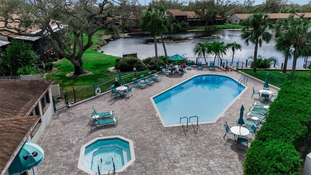 view of swimming pool with a water view and a patio