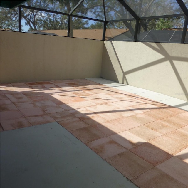 view of patio featuring glass enclosure