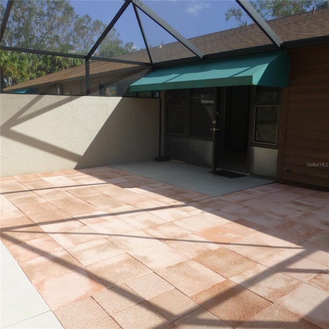 view of patio featuring glass enclosure