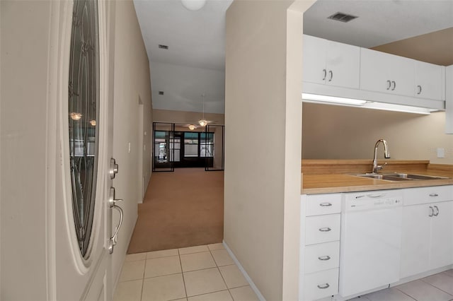 kitchen featuring dishwasher, white cabinetry, sink, and light carpet