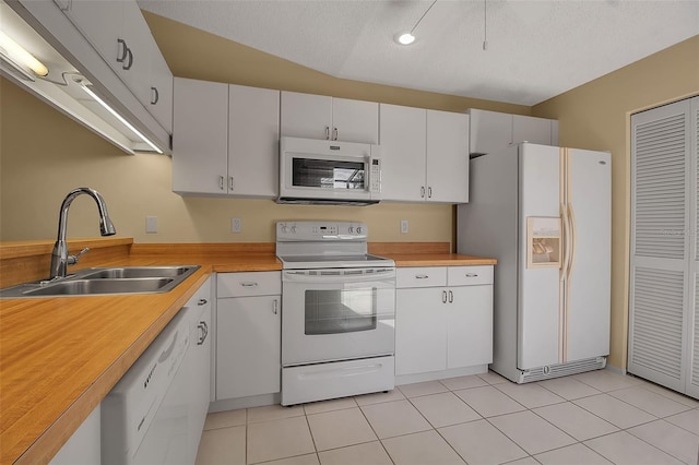 kitchen featuring a textured ceiling, white cabinetry, white appliances, and sink