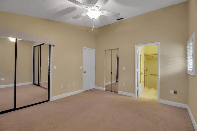 unfurnished bedroom with light carpet, connected bathroom, and ceiling fan