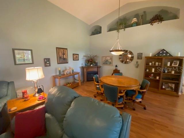 dining space with hardwood / wood-style flooring and high vaulted ceiling