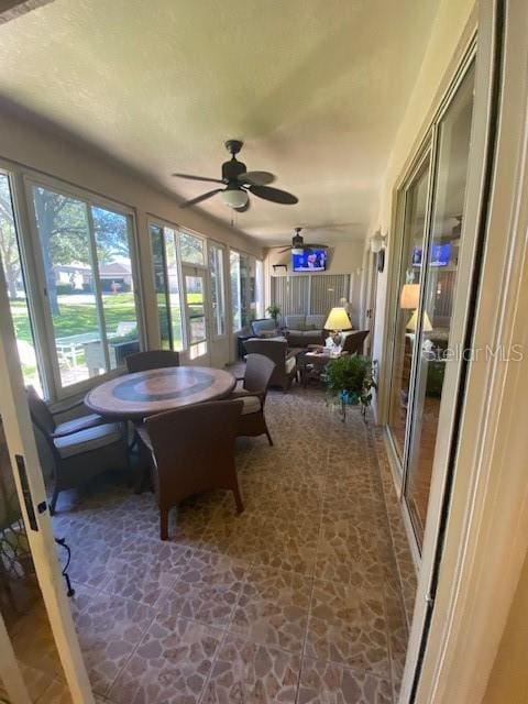 sunroom featuring ceiling fan