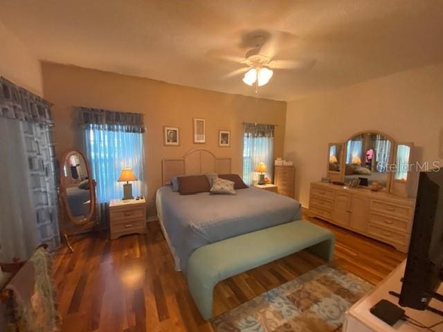 bedroom with dark hardwood / wood-style floors and ceiling fan