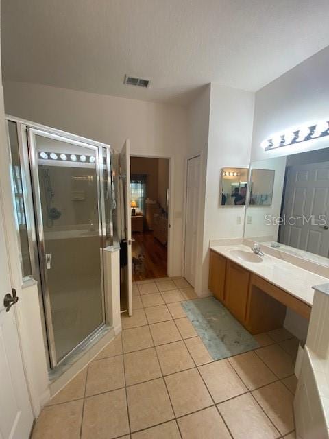 bathroom with vanity, tile patterned flooring, and a shower with door