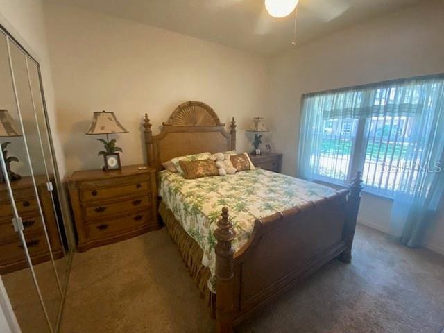 bedroom with a closet, ceiling fan, and dark colored carpet