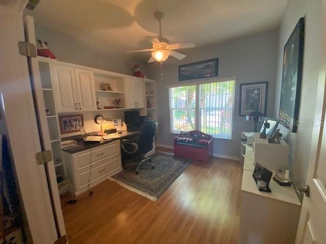 office area with built in desk, ceiling fan, and light hardwood / wood-style floors