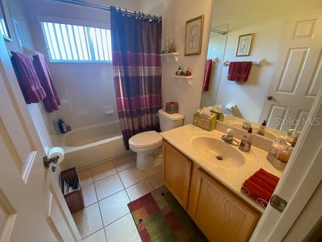 full bathroom with toilet, shower / bath combo, vanity, and tile patterned floors