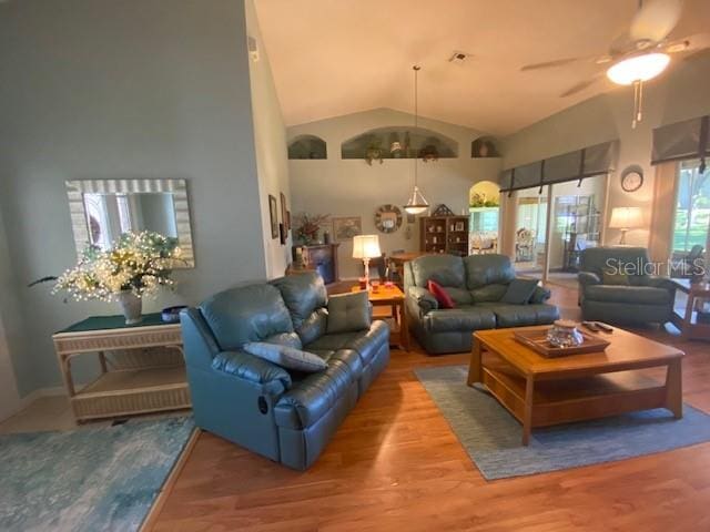 living room with lofted ceiling, hardwood / wood-style flooring, and ceiling fan