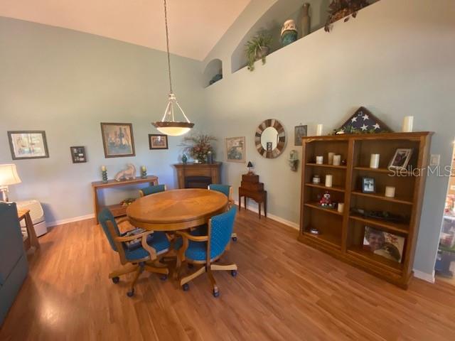 dining area featuring hardwood / wood-style floors and high vaulted ceiling