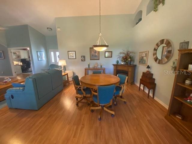 dining room with hardwood / wood-style floors and a towering ceiling