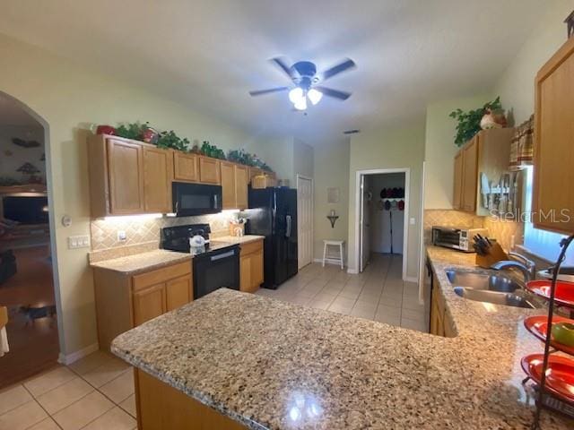 kitchen featuring kitchen peninsula, backsplash, sink, black appliances, and ceiling fan