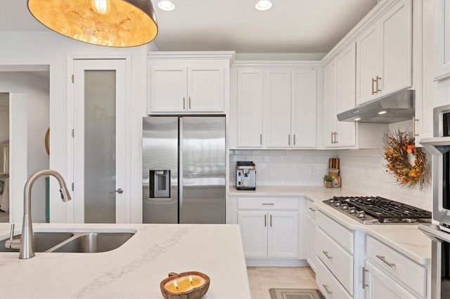 kitchen featuring tasteful backsplash, appliances with stainless steel finishes, sink, and white cabinets