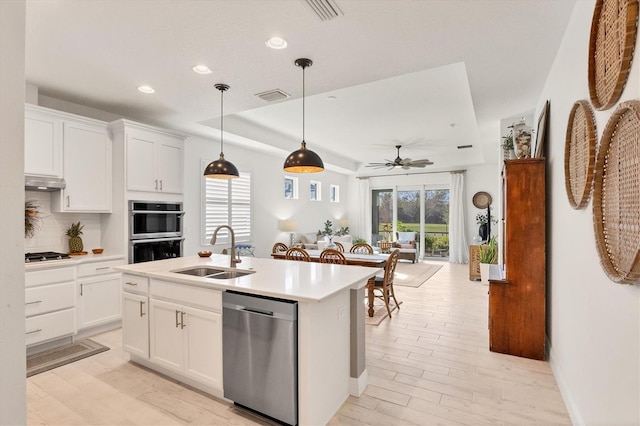 kitchen with a kitchen island with sink, sink, white cabinetry, appliances with stainless steel finishes, and ceiling fan