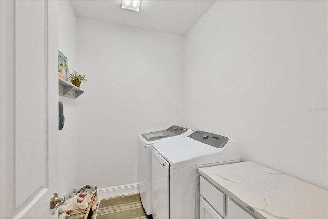 washroom with cabinets and washer and clothes dryer