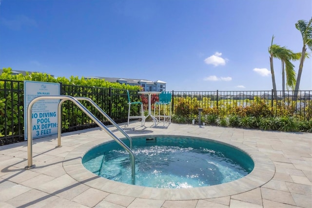 view of pool with a hot tub