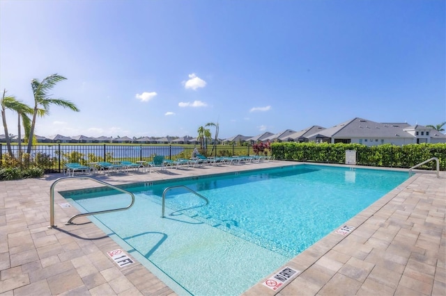 community pool featuring a patio area, a residential view, and fence