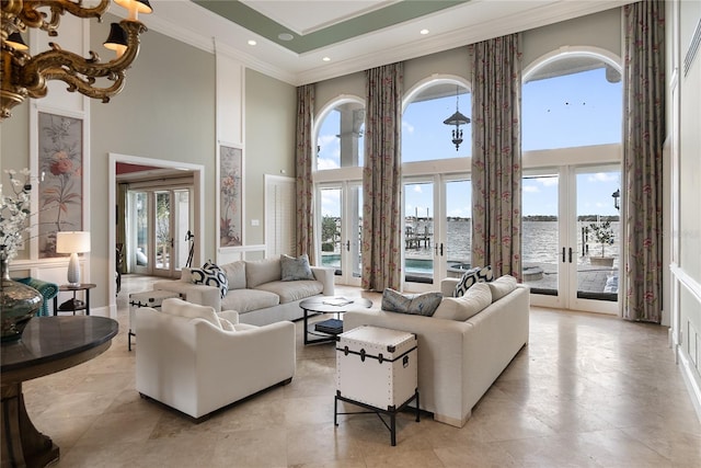 living room with french doors, a water view, ornamental molding, and a high ceiling