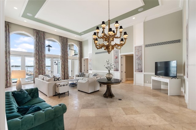 living room with a chandelier, crown molding, a towering ceiling, and french doors