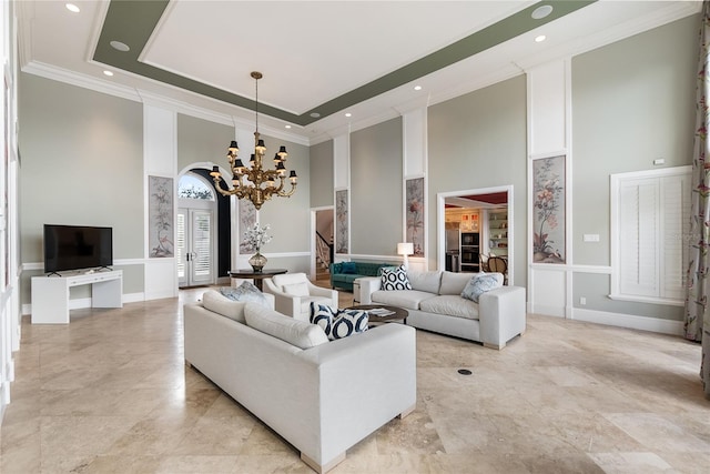 living room featuring crown molding, an inviting chandelier, and a high ceiling