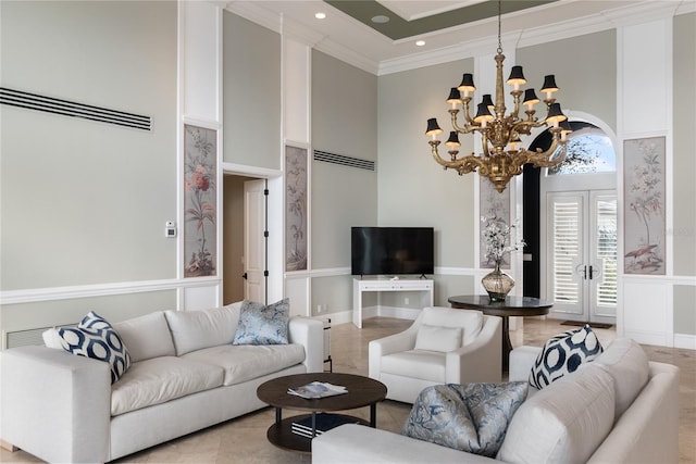 living room featuring ornamental molding, a chandelier, and a towering ceiling