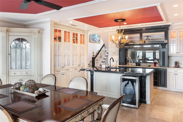 dining room with a wealth of natural light, sink, crown molding, and beverage cooler