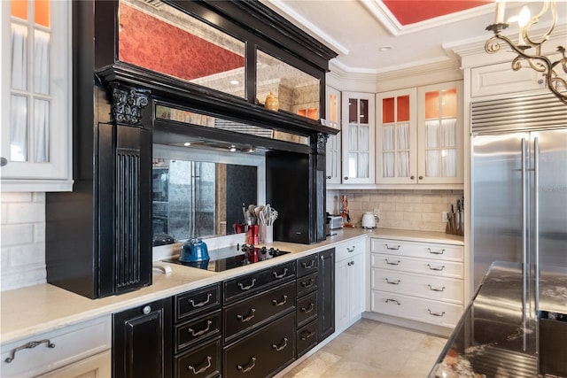 kitchen featuring decorative backsplash, white cabinetry, crown molding, built in fridge, and black electric stovetop