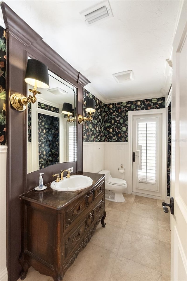 bathroom featuring vanity, ornamental molding, and toilet