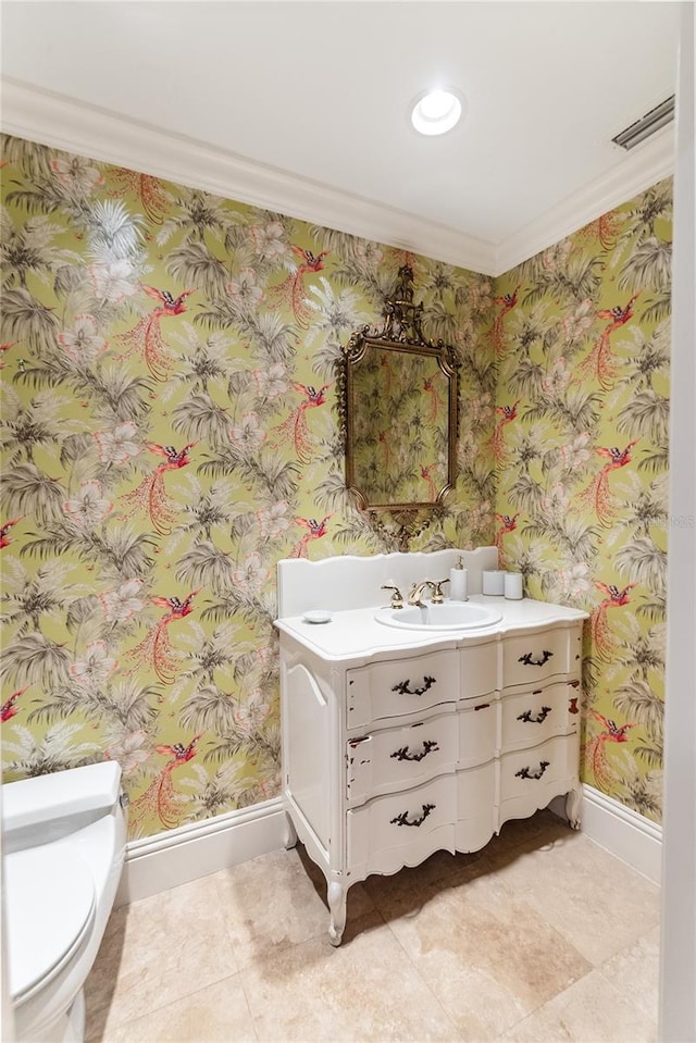 bathroom with vanity, crown molding, and toilet