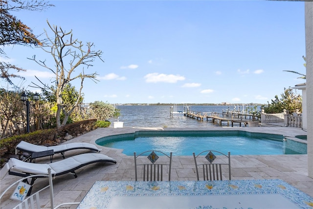 view of swimming pool with a water view, a patio, and a dock