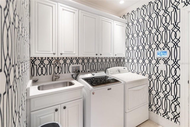 clothes washing area with sink, washer and clothes dryer, crown molding, and cabinets