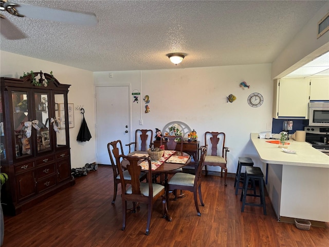 dining area featuring a textured ceiling and dark hardwood / wood-style floors