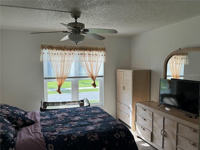 bedroom featuring carpet flooring, a textured ceiling, and ceiling fan