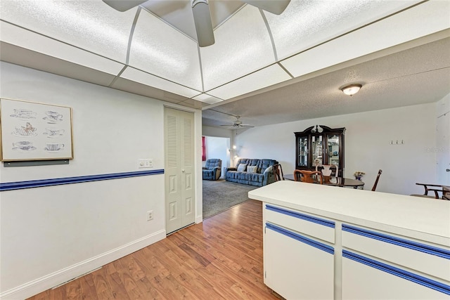 kitchen with light countertops, light wood-style floors, baseboards, and ceiling fan