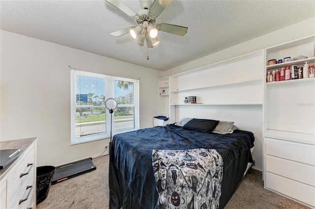 carpeted bedroom with ceiling fan and a textured ceiling