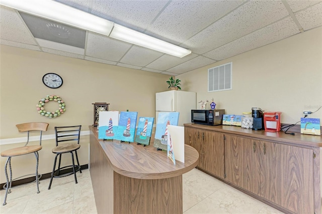 office area with visible vents and a drop ceiling