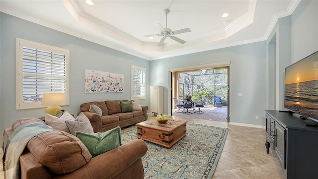 tiled living room featuring crown molding, a tray ceiling, and ceiling fan