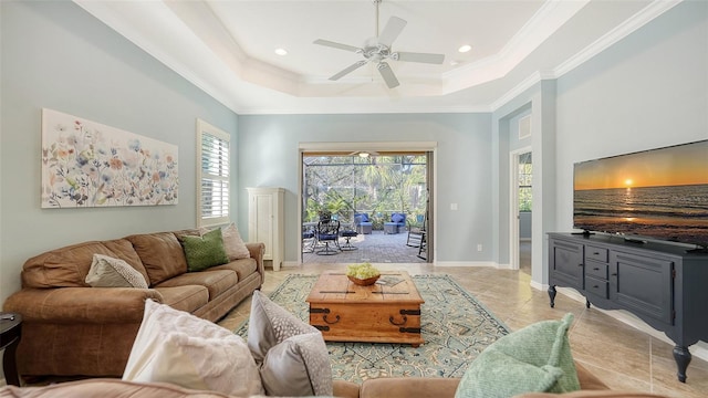 living room with ceiling fan, ornamental molding, and a tray ceiling