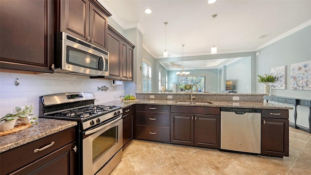 kitchen with appliances with stainless steel finishes, sink, kitchen peninsula, decorative light fixtures, and a chandelier